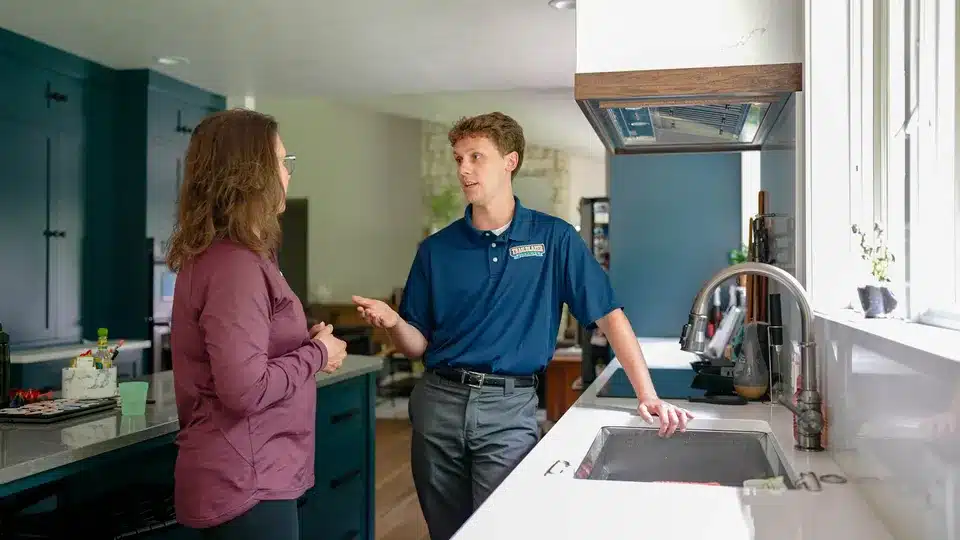 Trailblazer Plumbing tech helping customer in kitchen in Lockport.