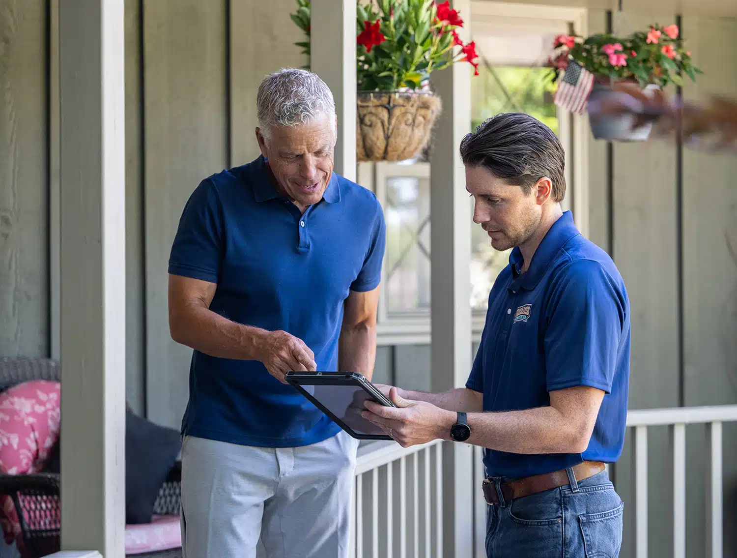 Trailblazer technician showing customer options in front of home.
