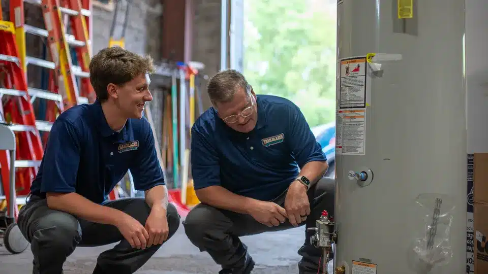 Trailblazer plumbing techs working on water heater in warehouse in Lockport.