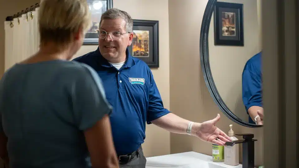 Trailblazer Plumbing technician helping customer in residential bathroom in Lockport.