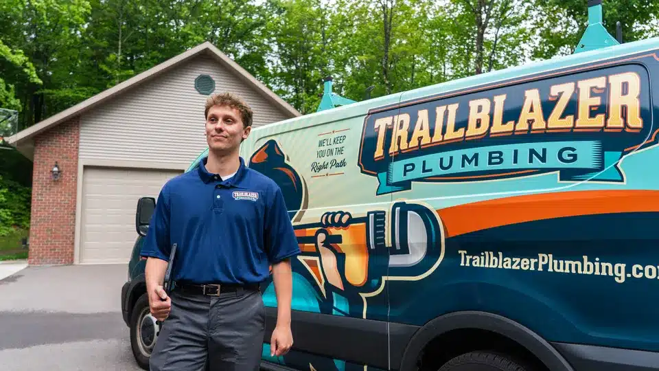 Trailblazer Plumbing tech standing in front of logo truck in Lockport.