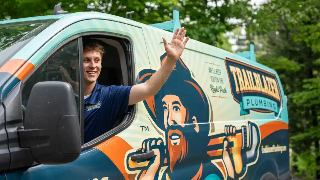 Trailblazer Plumbing tech waving out of van in Lockport.